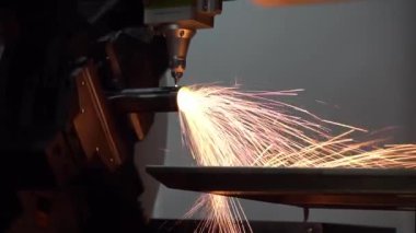 Yavaş çekim sahnesi, fiber lazer kesme makinesi paslanmaz çelik tüpü ve parlak ışığı kesti. Lazer kesme makinesinin yüksek teknoloji metal üretim süreci.. 