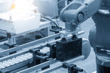 Akü üretim hattında robotik kol ile malzeme işleme süreci. Robotik sistem tarafından yüksek teknoloji materyal işleme süreci.