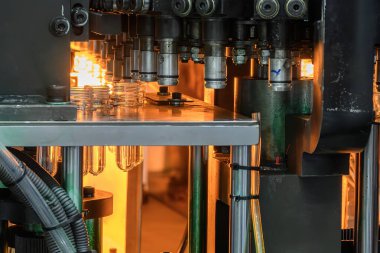 Taşıyıcı bant, önceden şekillendirilmiş şekli üfleme makinesine teslim eder. Plastik şişe üfleme makinesi operasyonu..