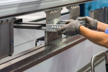 Hidrolik fren bükme makinesini kapat. Metal parçaları güvenlik eldiveniyle tut. Yetenek operatörünün kullandığı levha metal çalışması.