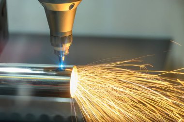 Sahneyi kapatın, fiber lazer kesme makinesi paslanmaz çelik tüpü ve lazer ışını ışığını kesti. Lazer kesme makinesinin yüksek teknoloji metal üretim süreci.. 