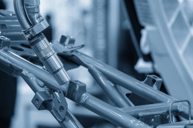 Otomotiv fabrikasındaki yüksek teknoloji lazer kaynak işlemi. Açık mavi sahnede robotik sistem tarafından otomatik montaj işlemi.