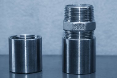 Sahneyi kapatın. Açık mavi sahnede paslanmaz çelik 304 boru bağlantısı. Açık mavi sahnedeki su tesisatı üretim süreci..