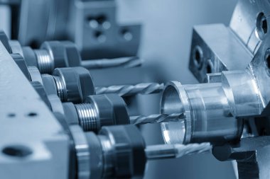 Çoklu görev yapan CNC torna makinesi İsviçreli tip metal şaft parçalarını deliyor. CNC dönüşüm makinesiyle çalışan yüksek teknoloji metali.