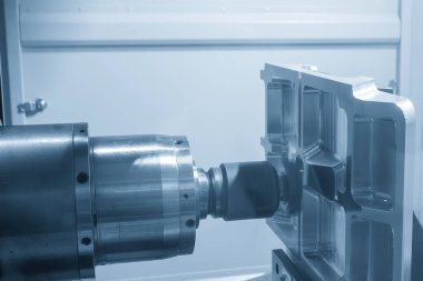 Yatay CNC değirmen makinesi açık mavi sahnede alüminyum parçaları indekslenebilir araçla kesiyor. Yatay eksen CNC makine merkezi ile kesme işlemi.