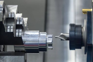Açık mavi sahnede CNC torna makinesindeki metal şaft parçalama işlemi. CNC dönüşüm makinesinin yüksek hassasiyetli metali.