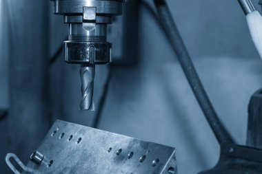 NC değirmen makinesi metal plaka parçalarını düz burun değirmeni aletiyle kesiyor. Açık mavi sahnede değirmen makinesiyle metal kesme işlemi.