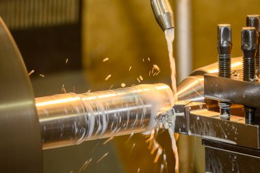 Torna makinesi metal şaft parçalarını sıvı soğutucu metoduyla kesiyor. Makineyi döndürerek metal işleme süreci.