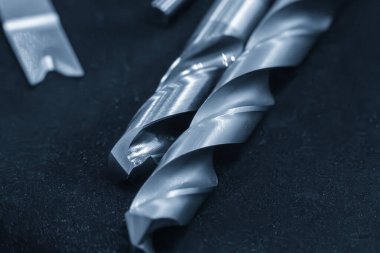 Açık mavi sahnede yakın çekim yeni matkap araçları. Makine merkezi için delik kesme aracı.
