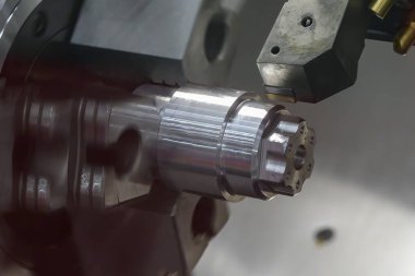 CNC Torna Makinesi, açık mavi sahnede metal şaft parçalarını kesiyor. CNC dönüşüm makinesinin yüksek teknolojili metal işlemesi .