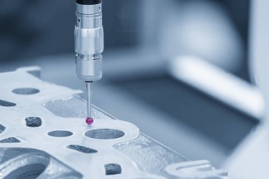 Açık mavi sahnede alüminyum silindir kafa parçalarını ölçen çok eksenli CMM makinesi. Çoklu eksen CMM makinesi ile otomotiv parçalarının kalite kontrolü