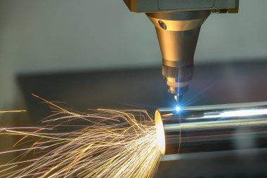 Sahneyi kapatın, fiber lazer kesme makinesi paslanmaz çelik tüpü ve parlak ışığı kesti. Lazer kesme makinesinin yüksek teknoloji metal üretim süreci.. 