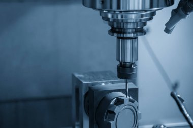 CNC değirmen makinesi açık mavi sahnede grafit elektrot parçalarını kesiyor. CNC makine merkezi tarafından üretilen kalıp ve ölüm süreci.