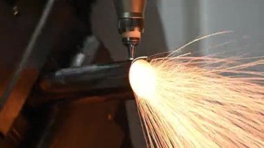 Sahneyi kapatın, fiber lazer kesme makinesi paslanmaz çelik tüpü ve parlak ışığı kesti. Lazer kesme makinesinin yüksek teknoloji metal üretim süreci.. 