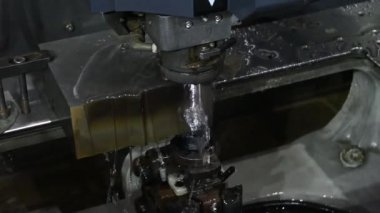 Kapanış sahnesinde EDM kablosu kalıbı keserek sıvı soğutma metoduyla parçalar yerleştirir. Zar atma işlemi CNC programı tarafından kablo kesme makine kontrolü ile kesme işlemi.