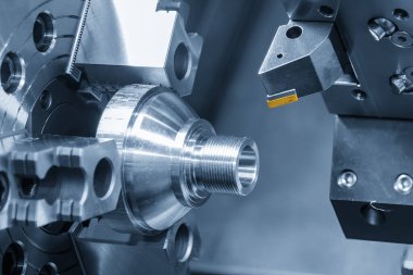 Açık mavi sahnede torna aracına iliştirilmiş kaplama çipi sahneyi kapat. CNC dönüşüm makinesinin yüksek teknoloji metal çalışma süreci.
