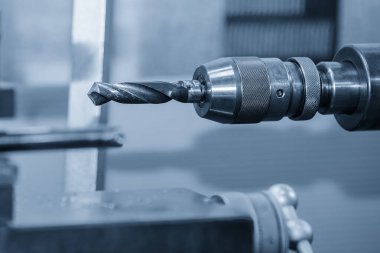 Torna makinesi açık mavi sahnedeki metal parçaları inceliyor. CNC dönüşüm makinesinin yüksek teknolojili metal işlemesi .