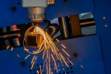 Sahneyi kapatın, fiber lazer kesme makinesi paslanmaz çelik tüpü ve parlak ışığı kesti. Lazer kesme makinesinin yüksek teknoloji metal üretim süreci.. 