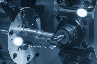 Çok yönlü CNC torna makinesi, açık mavi sahnede metal tüp parçalarını değirmenle öğütüyor. CNC dönüşüm makinesiyle çalışan yüksek teknoloji metali.
