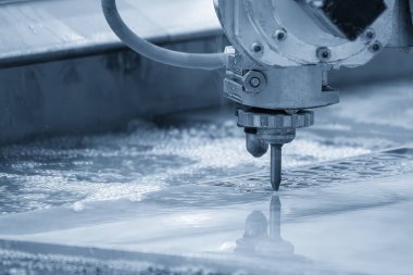 Çok eksenli yıpratıcı su jeti kesme makinesinin alüminyum plakayı kestiği yakın çekim sahnesi. CNC makinesiyle çalışan yüksek teknoloji levha metali.
