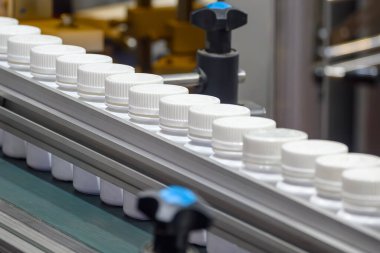 Doldurma işlemi için taşıyıcı banttaki ilaç şişesi. İlaç üretim konseptleri.. 