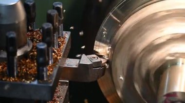 Torna makinesiyle pirinç maddenin parçalarını kesmek. Makineyi döndürerek metal işleme süreci.