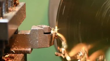 Ağır çekim sahnesi. Torna makinası pirinç parçaları kesmiş. Makineyi döndürerek metal işleme süreci.