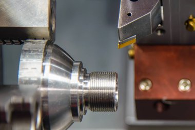 CNC torna makinesinin metal koni şeklindeki parçaları kestiği sahneyi kapatın. CNC dönüşüm makinesinin yüksek teknoloji metal çalışma süreci.