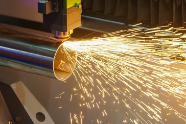 Sahneyi kapatın, fiber lazer kesme makinesi paslanmaz çelik tüpü ve parlak ışığı kesti. Lazer kesme makinesinin yüksek teknoloji metal üretim süreci.. 
