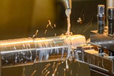 Torna makinesi metal şaft parçalarını sıvı soğutucu metoduyla kesiyor. Makineyi döndürerek metal işleme süreci.