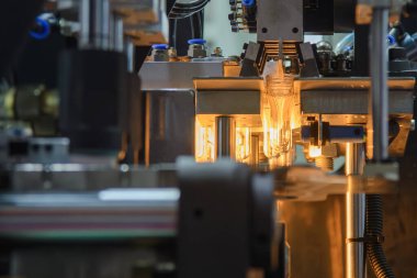 Taşıyıcı bant, önceden şekillendirilmiş şekli üfleme makinesine teslim eder. Plastik şişe üfleme makinesi operasyonu..