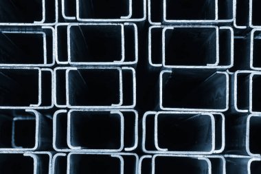 Açık mavi sahnedeki kare çelik boru profilini kapatın. İnşaat malzemeleri yığını. 