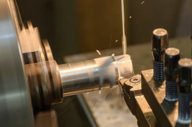 Torna makinesi metal şaft parçalarını sıvı soğutucu metoduyla kesiyor. Makineyi döndürerek metal işleme süreci.