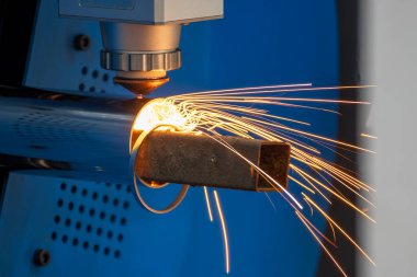 Sahneyi kapatın, fiber lazer kesme makinesi paslanmaz çelik tüpü ve parlak ışığı kesti. Lazer kesme makinesinin yüksek teknoloji metal üretim süreci.. 