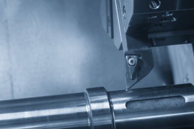 CNC Torna Makinesi, aydınlatma efektiyle açık mavi sahnede metal şaft parçalarını kesiyor. CNC dönüşüm makinesinin yüksek teknolojili metal işlemesi.