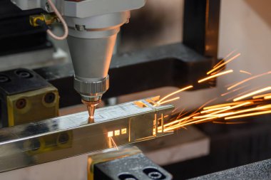Sahneyi kapatın, fiber lazer kesme makinesi kare şeklindeki paslanmaz çelik tüpü parlak ışıkla kesti. Lazer kesme makinesinin yüksek teknoloji metal üretim süreci.. 