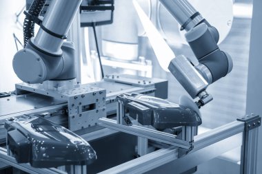 Açık mavi sahnede robotik sistem tarafından parlatılan otomotiv parçaları. Otomatik sisteme göre yüksek teknoloji araba boyama işlemi.