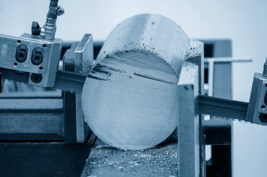 Şerit, açık mavi sahnede metal şaft parçalarını soğutucu metoduyla kesen makineyi gördü. Endüstriyel amaç için makine aracı.