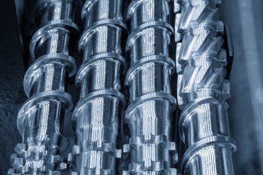 Açık mavi sahnede, enjeksiyon makinesinin namlu vidasının yedek parçalarını kapatın. Üretim konsept enjeksiyon makinesi .