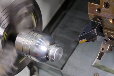 CNC torna makinesi metal şaft parçalarını kesiyor. CNC dönüşüm makinesinin yüksek teknolojili metal işlemesi.