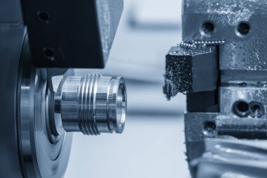 CNC torna makinesi ışık efektiyle açık mavi sahnedeki metal şaft parçalarını kesiyor. CNC dönüşüm makinesinin yüksek teknolojili metal işlemesi .