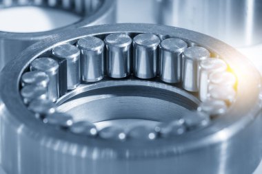 The cylindrical rolling bearing parts in light blue scene. The heavy mechanical part manufacturing concept.
