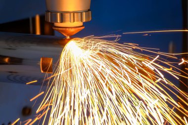 Sahneyi kapatın, fiber lazer kesme makinesi paslanmaz çelik tüpü ve parlak ışığı kesti. Lazer kesme makinesinin yüksek teknoloji metal üretim süreci.. 