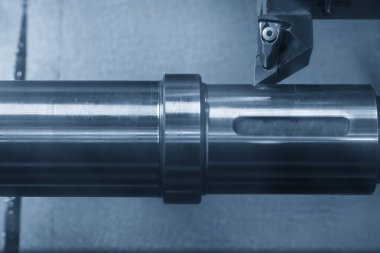 CNC Torna Makinesi, aydınlatma efektiyle açık mavi sahnede metal şaft parçalarını kesiyor. CNC dönüşüm makinesinin yüksek teknolojili metal işlemesi.