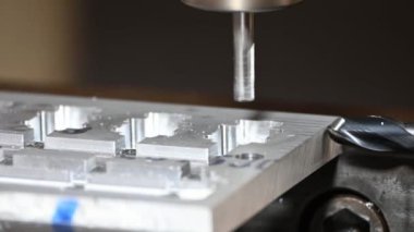 CNC değirmen makinesinin alüminyum parçalarını düz burun değirmeni aletleriyle kestiği sahneyi kapatın. Kalıplar, sert top değirmeni ile makine merkeziyle kesme işlemi yapıyor.