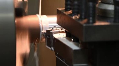 Torna makinesinin metal şaft parçalarını sıvı soğutucu metoduyla kestiği sahne. Makineyi döndürerek metal işleme süreci.