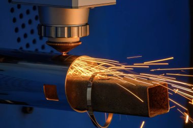 Sahneyi kapatın, fiber lazer kesme makinesi paslanmaz çelik tüpü ve parlak ışığı kesti. Lazer kesme makinesinin yüksek teknoloji metal üretim süreci.. 