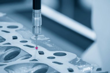 Açık mavi sahnede alüminyum silindir kafa parçalarını ölçen CMM makinesi. Çoklu eksen CMM makinesi ile otomotiv parçalarının kalite kontrolü