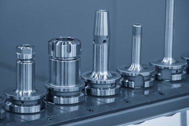 Açık mavi sahnede çeşitli tip CNC araç tutucu yakın sahne. Makine merkezi için araç tutucu ve ekipman.