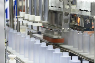 Kozmetik şişe üretim sürecinin yüksek teknolojisi. Süreci tamamlamak için taşıyıcı banttaki boş sağlık şişeleri. 